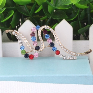 Macro shot of wavy gold brooch with colorful multi-shade rhinestones and crystals