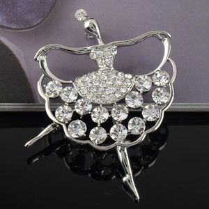 Détail d'une broche danseuse de ballet argentée sertie de strass brillants sur fond noir