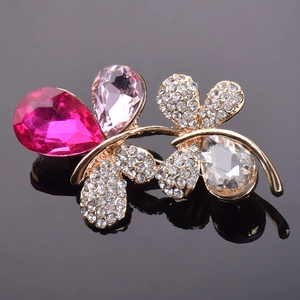 Macro de broche papillon avec cristaux roses en forme de goutte sur base dorée
