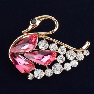 Nahaufnahme der Schwanenbrosche mit rosa Kristalltropfen und weißen Strasssteinen