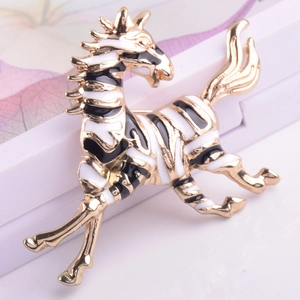 Detailed view of a golden zebra brooch with black and white enamel finish on a soft background