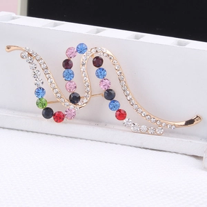 Close-up of elegant golden wave brooch featuring vibrant multi-colored inlaid rhinestones