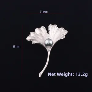 Detail showing the brushed silver ginkgo leaf brooch with grey pearl and sparkling rhinestones