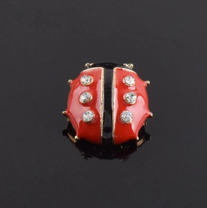 Macro de la broche coccinelle en émail rouge avec des pierres de zircon brillant