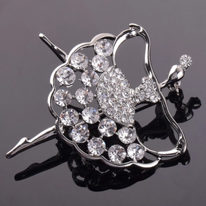 Broche ballerine en argent scintillante avec cristaux blancs sur fond noir réfléchissant