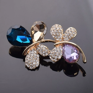 Vue macro d'une broche papillon avec cristaux en goutte et plaquage or
