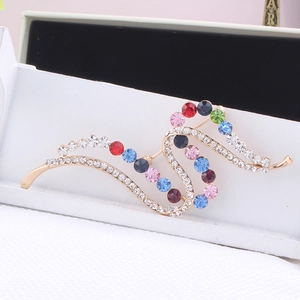 Detailed macro view of colorful crystal wave brooch in a white jewelry gift box