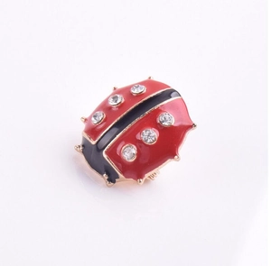Détail de la broche coccinelle en émail rouge et noir avec strass scintillants