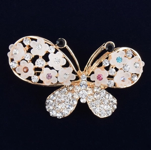 Eleganter Schmetterling Brosche mit weißen Blumen und bunten Kristallen auf dunklem Grund