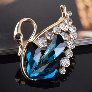 Detail einer eleganten goldenen Schwanenbrosche mit blauen Kristallen und Strasssteinen