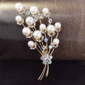 Broche fleur dorée élégante avec perles blanches et cristaux sur fond en cuir marron