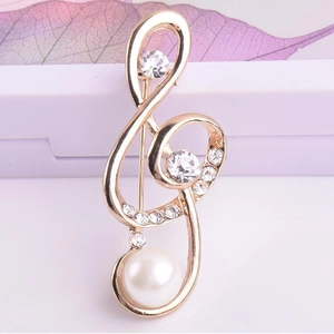 Élégante broche note de musique dorée avec strass et une grande perle blanche ronde