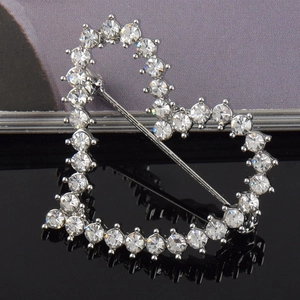 Macro shot of silver heart brooch with sparkling crystals and secure pin closure