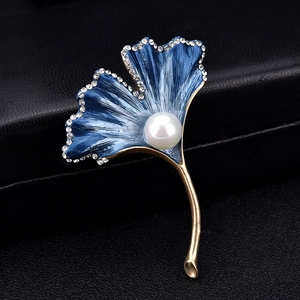 Macro detail of ginkgo leaf brooch with blue enamel, white pearl and sparkling crystals