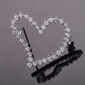 Close-up of heart-shaped brooch with silver alloy and sparkling white crystal rhinestones