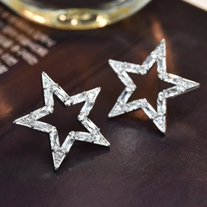 Macro shot of silver star stud earrings with pave set crystal zircon on dark leather