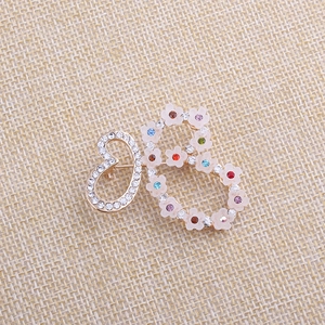 Detail der künstlerischen Schmetterlingsbrosche mit bunten Strasssteinen und Blumen