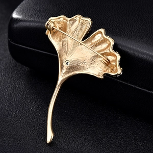 Macro shot of the secure pin fastening on the back of the golden ginkgo leaf brooch