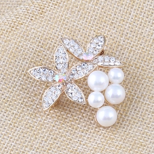 Detailaufnahme der Kristall-Blumenbrosche mit eleganten Perlen und goldener Basis