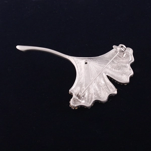 Detailed back view of silver ginkgo leaf brooch showing safety pin clasp and metal texture
