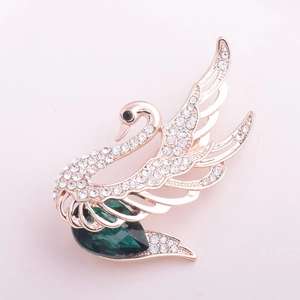 Élégante broche cygne en or rose avec cristaux blancs et une grande pierre verte en goutte