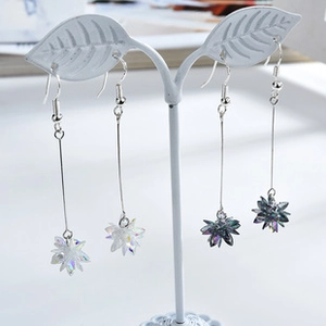 Detail of long dangle starburst earrings with faceted colorful crystals in two shades