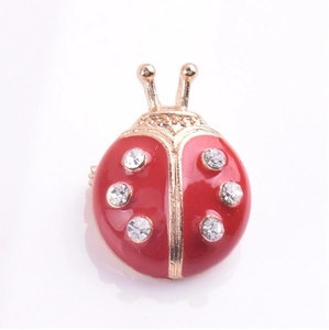 Gros plan détaillé d'une broche coccinelle mignonne avec des ailes en émail rouge et strass