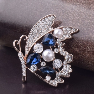 Broche papillon élégante avec cristaux bleus et perles sur monture or rose