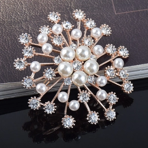 Gros plan détaillé de la broche perle flocon de neige avec finition or rose et strass