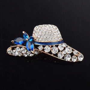 Macro detail of a crystal hat brooch with blue gemstones and sparkling pave rhinestones