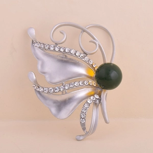 Broche papillon argentée ornée de strass blancs et d'une grande perle vert foncé