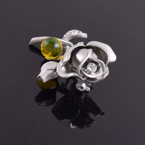 Détail d'une broche rose argentée avec ambre jaune et accents de cristaux brillants