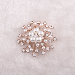 Détail d'une broche perle en étoile avec cristaux scintillants sur fond en peluche