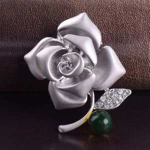 Elegant silver rose brooch with sparkling crystal leaf and deep green gemstone bead
