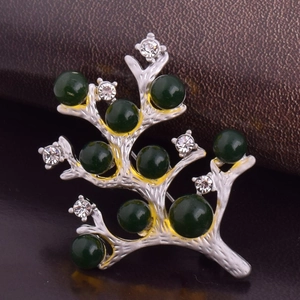 Détail d'une broche branche de sapin argentée avec perles vert foncé et cristaux blancs