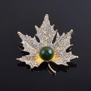 Élégante broche feuille d'érable dorée avec pierre précieuse verte et cristaux blancs