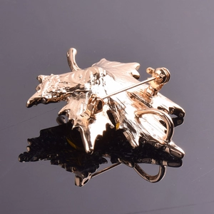 Détail du dos d'une broche en forme de feuille d'érable dorée avec fermoir de sécurité