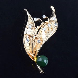 Elegante spilla a fiore di mughetto in oro con cristalli bianchi e perla verde