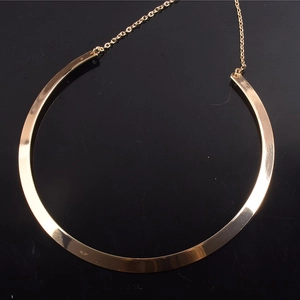 Macro detail of gold-toned punk choker showing metallic mirror finish and delicate chain link