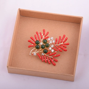 Détail de la broche style corail avec branches rouges dans une boîte cadeau