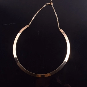 Macro view of gold punk metal choker necklace with polished finish and lobster clasp