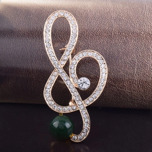Elegant gold musical note brooch with sparkling crystals and deep green pearl bead