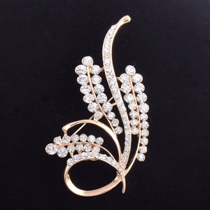 Broche fleur dorée élégante avec cristaux scintillants et glands courbés sur fond noir
