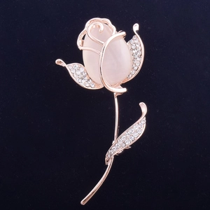 Détail de la broche rose en or rose avec pierre oeil de chat rose et cristaux blancs