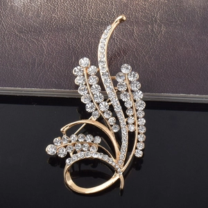 Gros plan d'une broche fleur dorée élégante ornée de cristaux et design d'épis de blé