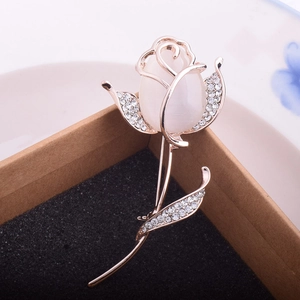 Détail d'une broche fleur en or rose avec pierre oeil de chat et strass étincelants