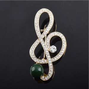 Elegant treble clef music note brooch with crystals and green pearl on black base