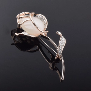 Gros plan détaillé de la broche fleur en or rose avec opale et strass scintillants