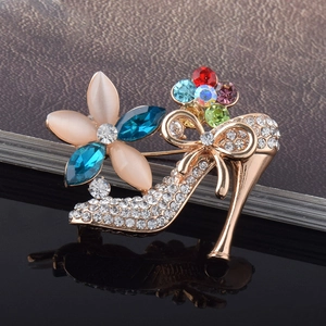 Détail d'une broche en forme de chaussure à talons avec cristaux colorés et dorure rose