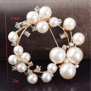 Detalle de broche de corona de perlas con medidas de 5,3 cm y un peso total de 22 g